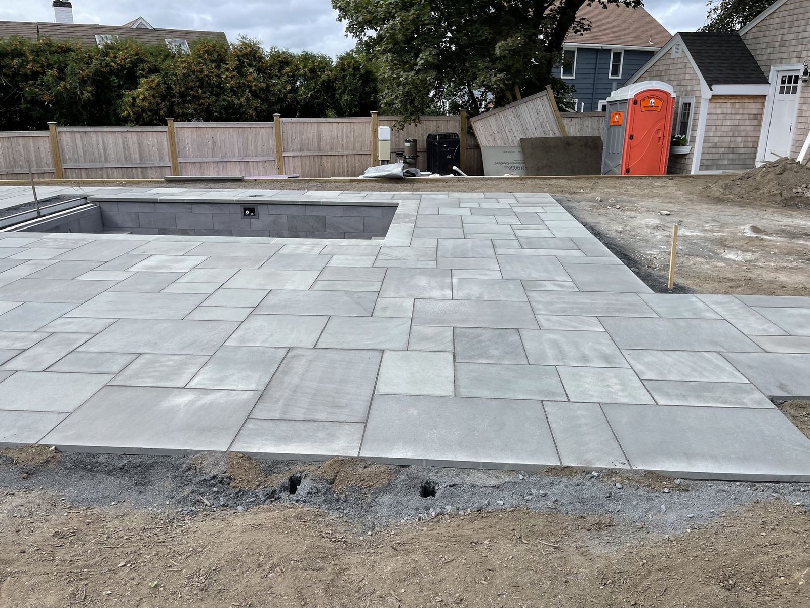 Large-format bluestone pool deck set in an ashlar pattern before final grading